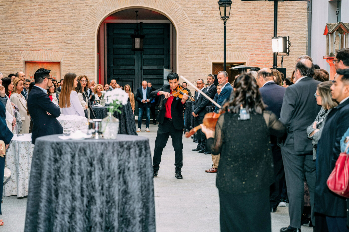 Violinista tocando entre los invitados de un evento corporativo en un patio de Zaragoza